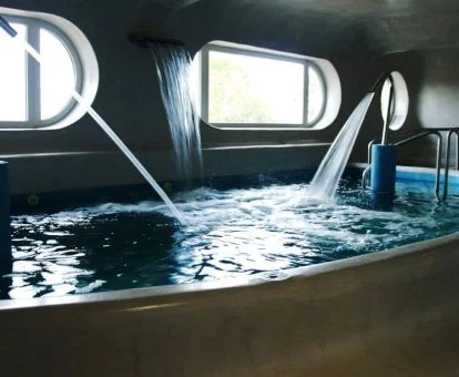 Piscina cubierta con elementos de hidroterapia del spa del hotel.