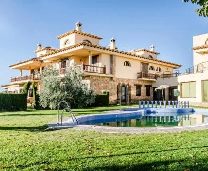 Hermoso hotel rural con amplios jardines y piscina exterior.