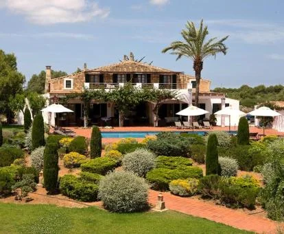 Fabuloso hotel rural rodeado de amplios jardines con piscina exterior.