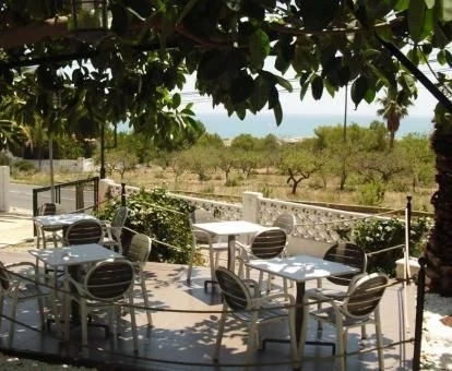 Terraza con comedor exterior y vistas al mar de este hotel con encanto.