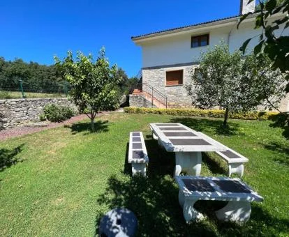 Acogedor hotel rural con amplios jardines y mobiliario exterior.