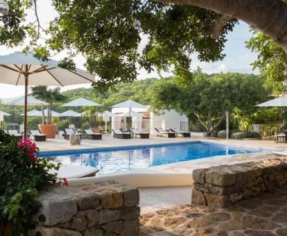 Amplia zona exterior con piscina y tumbonas con vistas a las montañas de este hotel rural.