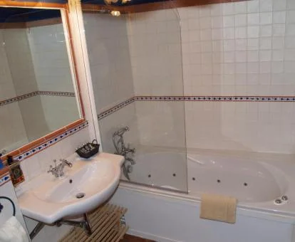 Baño con bañera de hidromasaje privada del apartamento dúplex de este establecimiento.