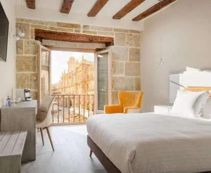 Una de las habitaciones tradicionales con balcón y vistas a la ciudad del hotel.