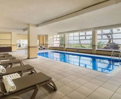 Instalaciones de bienestar con piscina cubierta con vistas al exterior y jacuzzi.