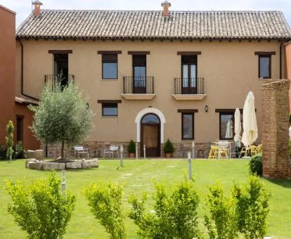 Edificio de este hotel rural con amplios jardines y mobiliario exterior.