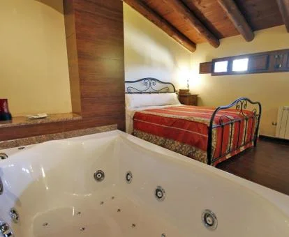 Apartamento dúplex con bañera de hidromasaje privada junto a la cama de este establecimiento.