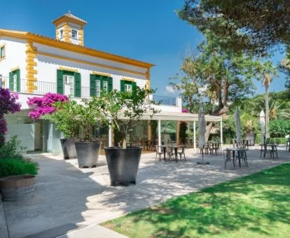 Fachada de este precioso hotel con bellos jardines y terraza.