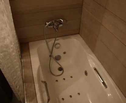 Bañera de hidromasaje privada en el baño de este acogedor apartamento.