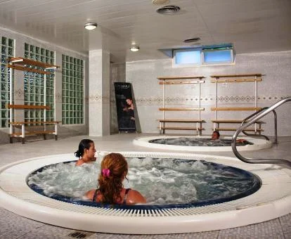 Varias personas disfrutando de la zona de aguas del spa.