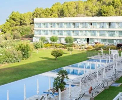 Hotel con amplia piscina y jardines rodeado de naturaleza y espacios para hacer senderismo.