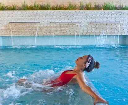 Mujer disfrutando de la piscina de hidroterapia del spa del hotel.