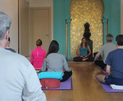 Un grupo de personas disfruta de una clase de yoga en una de las salas del alojamiento.