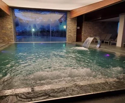 Piscina con elementos de hidroterapia del centro de bienestar del hotel.
