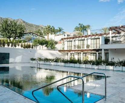 Hermoso hotel rural con piscina exterior y vistas a las montañas de los alrededores.