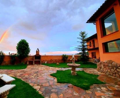 Terraza ajardinada con barbacoa de este hotel rural.