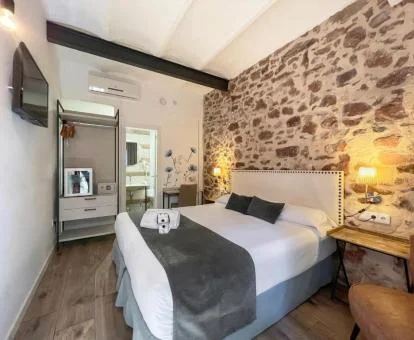 Una de las coquetas habitaciones con paredes de piedra a la vista del hotel.