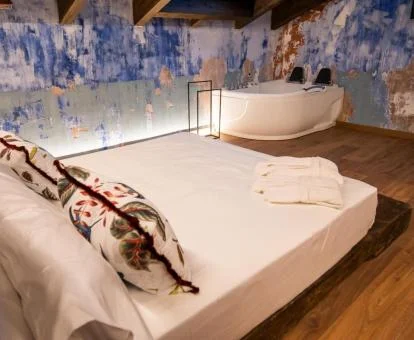 Una de las hermosas habitaciones dobles con jacuzzi privado cerca de la cama de este acogedor hotel boutique.
