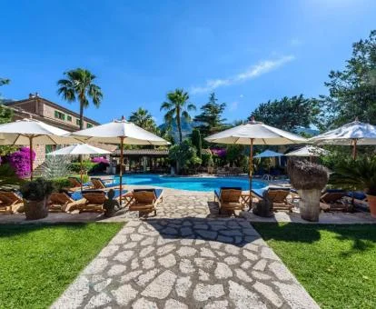 Hotel rural con piscina exterior y rodeado de jardines.