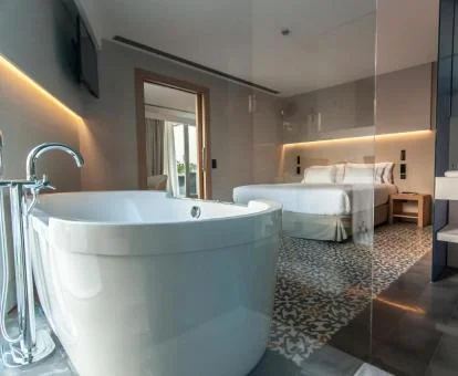 Una de las amplias habitaciones con bañera cerca de la cama del hotel.