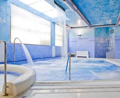 Piscina cubierta con elementos de hidroterapia del spa del hotel.