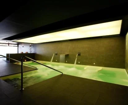 Piscina interior con elementos de hidroterapia del spa del hotel.