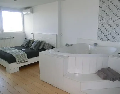 Foto del jacuzzi que se encuentra junto a la cama en la suite con bañera de hidromasaje en el bed and breakfast Syt Luxury