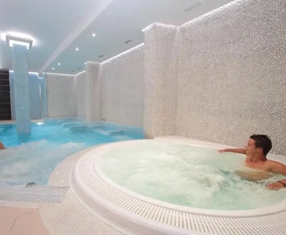 Hombre disfrutando del jacuzzi del spa del hotel.