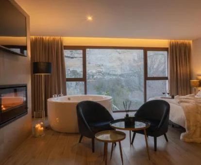 Dormitorio con un amplio jacuzzi junto a la cama y vistas al exterior de este precioso apartamento suite.