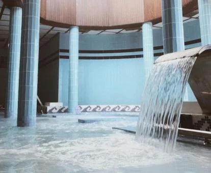 Preciosa piscina cubierta con elementos de hidroterapia del spa del hotel.