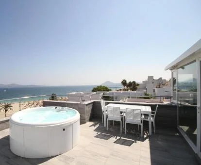 Amplia terraza amueblada de este apartamento con vistas al mar y jacuzzi privado.