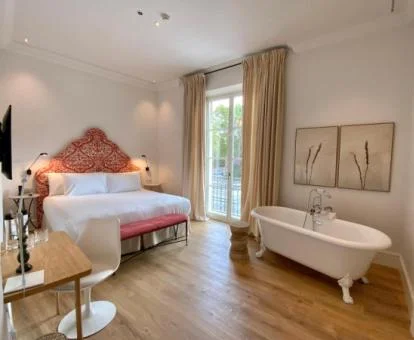 Una de las elegantes habitaciones con bañera cerca de la cama de este hotel boutique.