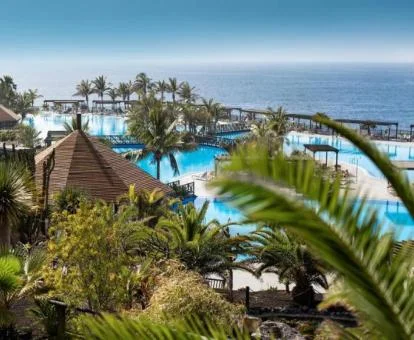 Espectacular zona exterior de este hotel con encanto con vistas al mar, piscinas y jardines tropicales.