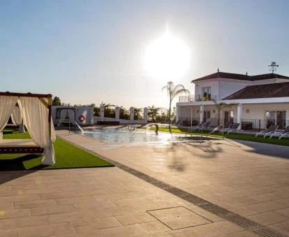 Zona exterior de este precioso hotel con piscina y camas balinesas.
