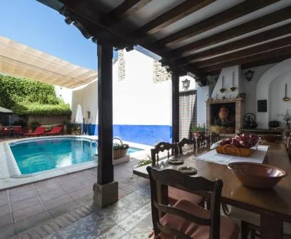 Acogedora zona con piscina exterior y mobiliario bajo porche de este hotel boutique tradicional.