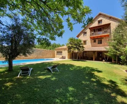 Hotel rural con amplios jardines y piscina exterior.