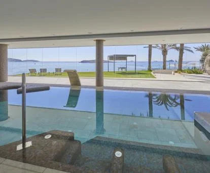 Gran piscina cubierta con elementos de hidroterapia y fabulosas vistas al mar del spa.