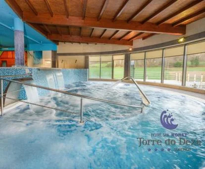 Gran piscina cubierta con elementos de hidroterapia del spa del hotel.