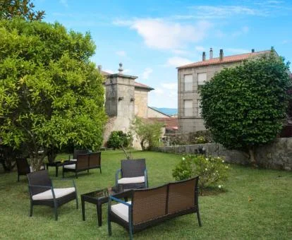 Agradable zona exterior ajardinada con mobiliario de este hotel boutique.