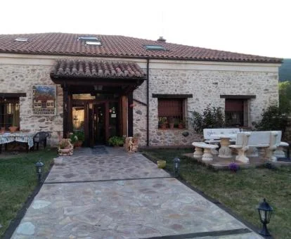 Caserón de estilo rústico con paredes de piedra a la vista y amplios jardines.