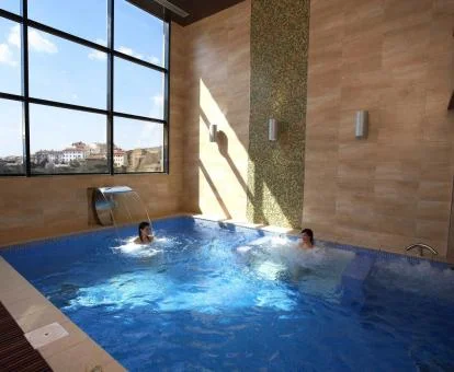 Pareja disfrutando de la piscina de hidroterapia del spa del hotel.