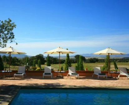 Maravillosa zona exterior con piscina y espectaculares vistas al campo de este elegante hotel.