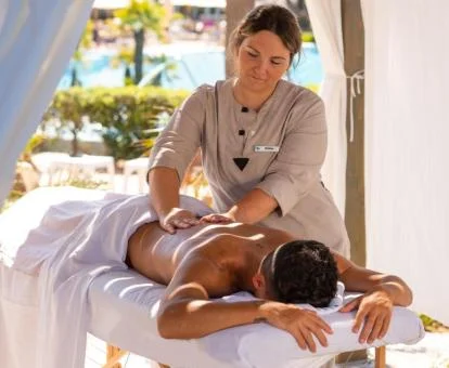 Hombre disfrutando de un masaje en las salas de bienestar del jardín del hotel.