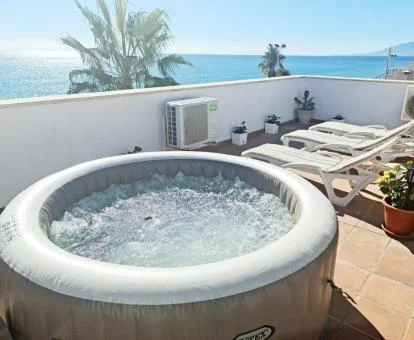 Amplia terraza con jacuzzi privado y vistas al mar de uno de los apartamentos con terraza del establecimiento.