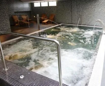 Piscina cubierta con elementos de hidroterapia del spa del hotel.