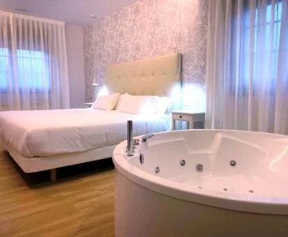 Dormitorio con bañera de hidromasaje privada del apartamento superior de este establecimiento.