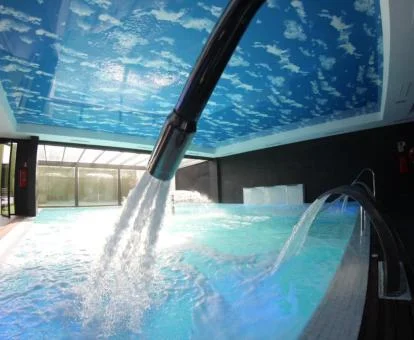 Piscina cubierta con elementos de hidroterapia del spa del hotel.