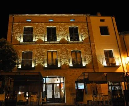 Edificio con iluminación nocturna y terraza exterior de este hotel con encanto.