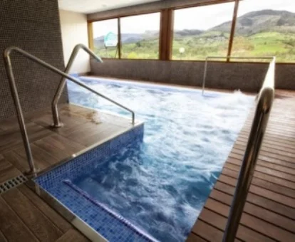 Piscina con elementos de hidroterapia y vistas al exterior.