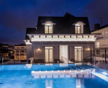 Edificio de este coqueto hotel boutique con iluminación nocturna y piscina exterior.